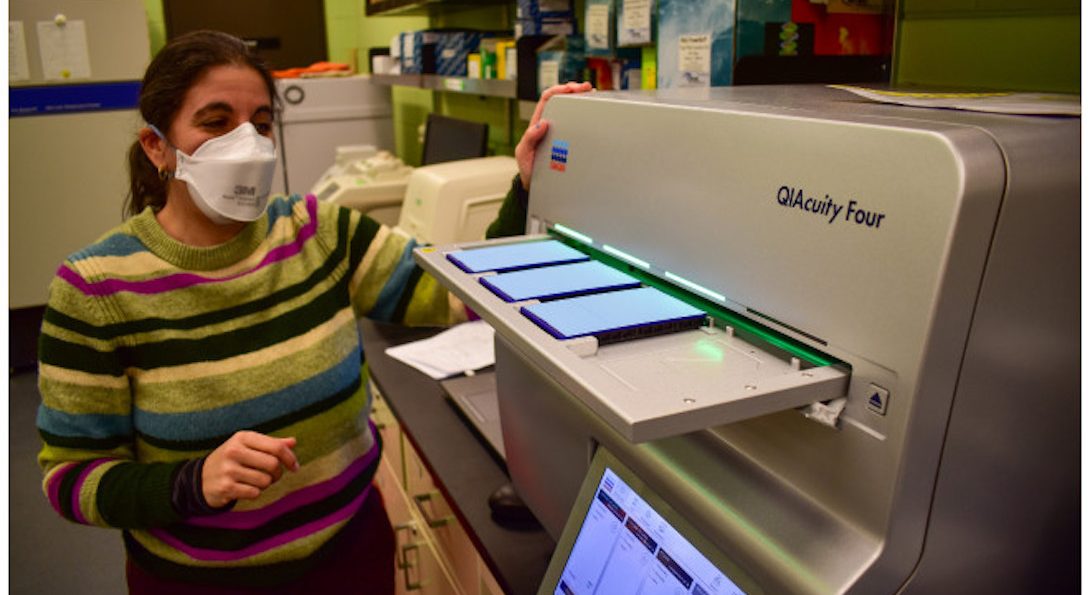 Rachel Poretsky stands next to The Poretsky Lab's digital PCR machine