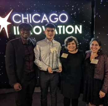a group of people in front of a neon sign that says Chicago innovation
                  